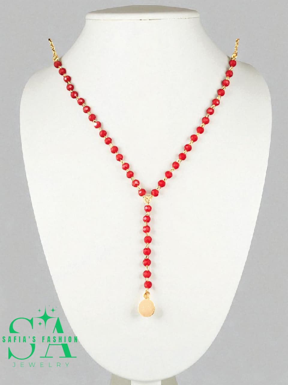 Red beaded necklace with a gold clasp on a white mannequin bust, branded 'Safia's Fashion'.