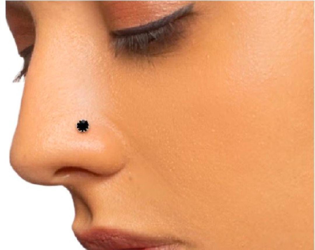 Close-up of a person wearing a black nose ring on a white background