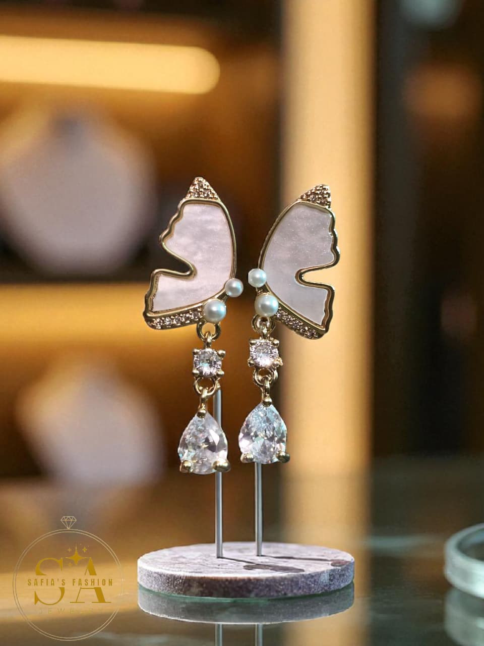 Butterfly-shaped earrings on a stand with a blurred background